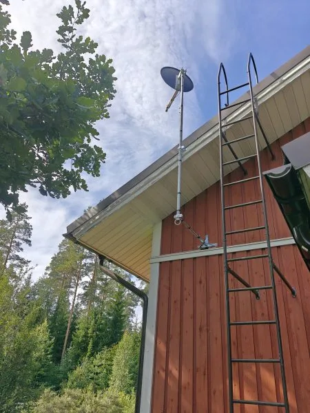 Satelliittiantennin asennus talonpäätyyn.